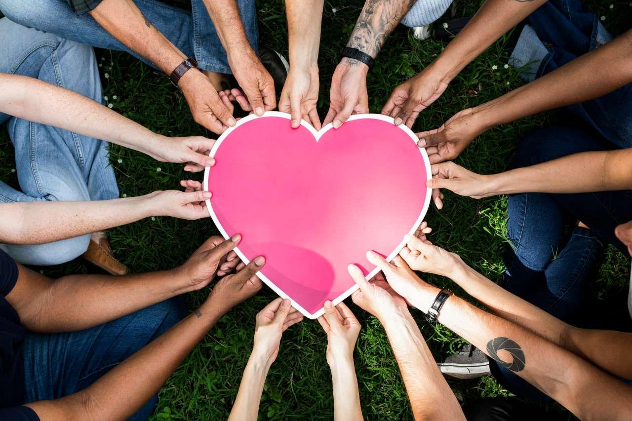 People in a circle holding a heart